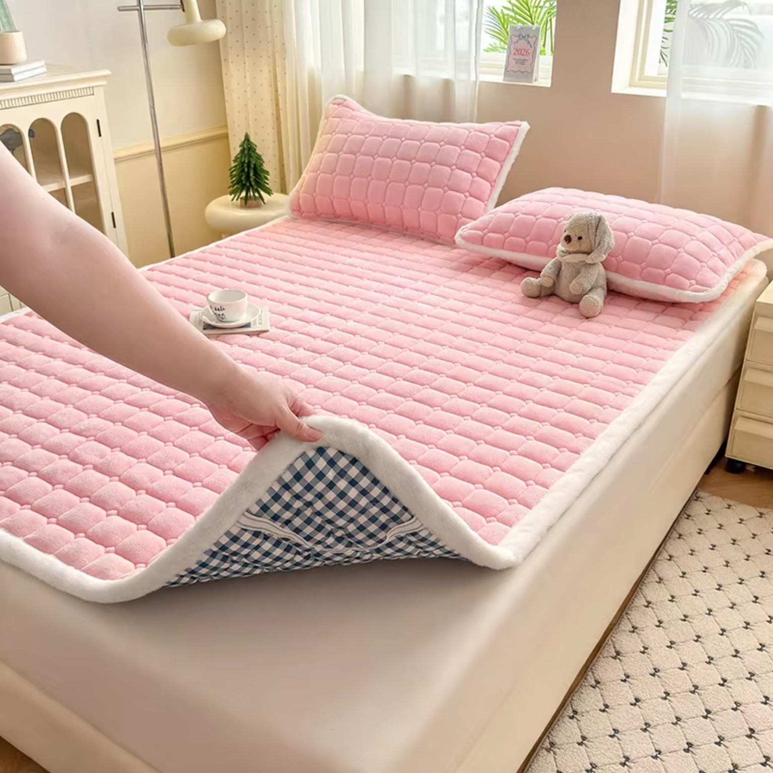 Pink quilted fleece mattress pad on bed